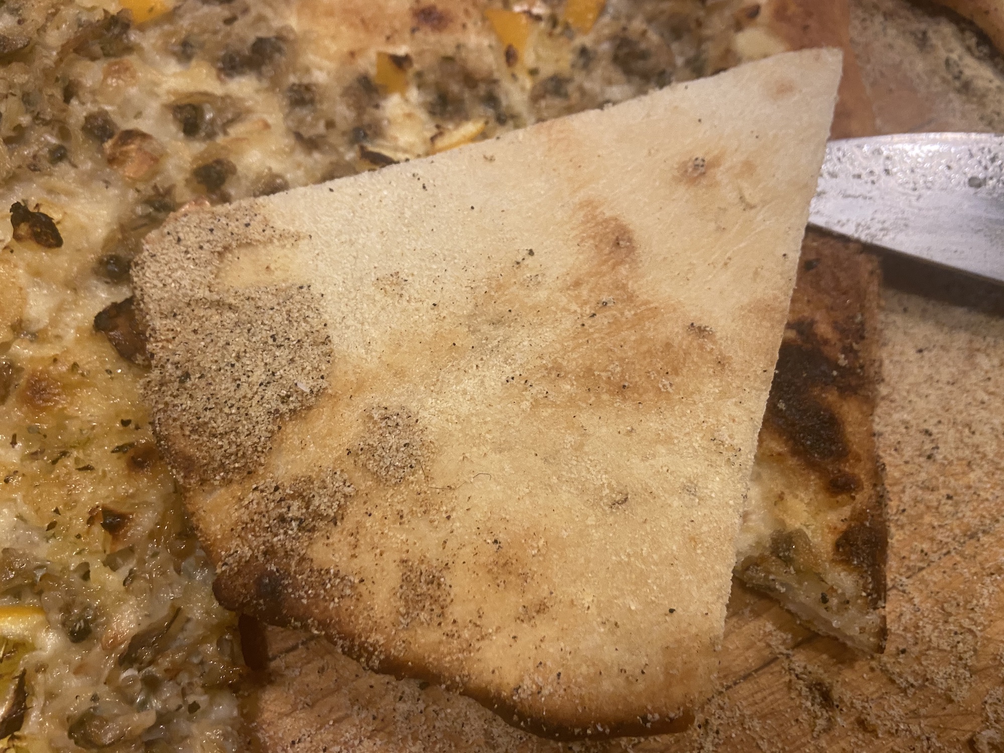 bottom of my clam pizza with some residual semolina that can be brushed off.